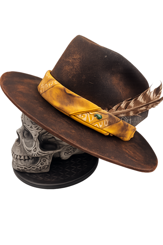 Brown hat with yellow band and feather on a skull-shaped stand against a white background